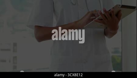 Tipizzazione operatore sanitario indossando cappotto bianco e stetoscopio in clinica per finestra, con compressa Foto Stock