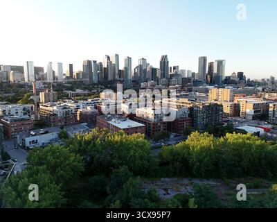 Vista aerea del moderno quartiere sul lungomare con edifici alti e sentieri lungo il fiume, skyline crepuscolare di Montreal. g.. Foto Stock