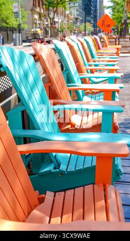 Toronto ON, Canada - 4 luglio 2022: Vivaci sedie Adirondack in turchese e arancione sono disposte lungo una strada soleggiata, invitante relax e superba Foto Stock