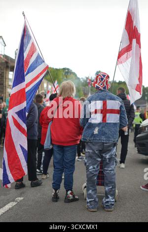 Due persone sono in piedi con una bandiera dell'Unione e una bandiera di San Giorgio a una protesta anti-immigrazione al Sandpiper Hotel, Unstone, Chesterfield. Foto Stock