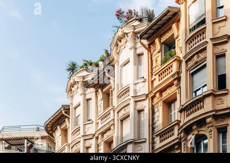 Eleganti edifici residenziali in Meyerbeer Street con balconi ornati e vegetazione sul tetto Foto Stock