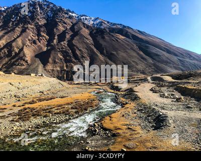 A oltre 3000 metri, un torrente ghiacciato scorre attraverso la remota natura selvaggia del Karakoram, trasportando l'acqua di fusione pura degli antichi ghiacciai Foto Stock