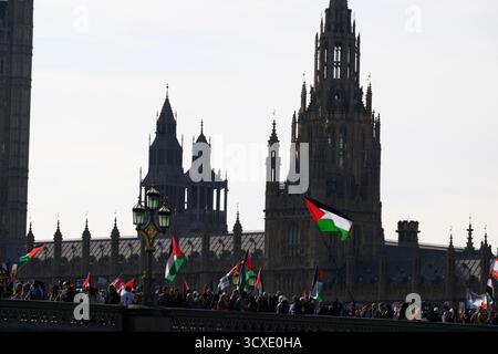 Manifestanti in una marcia pro-Palestina che attraversa il ponte di Westminster con la camera del Parlamento sullo sfondo. La marcia è iniziata a Victoria Embankmen Foto Stock