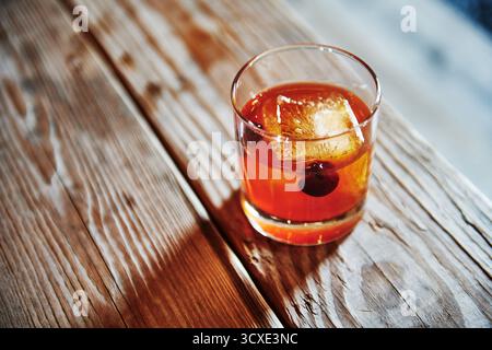 Cocktail vecchio stile seduto su un tavolo di legno Foto Stock
