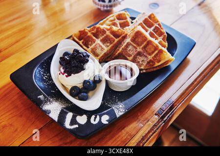 Waffle con gelato, mirtilli e sciroppo d'acero Foto Stock
