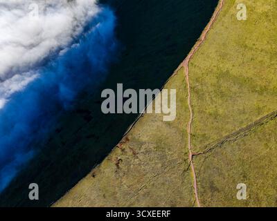 Vista dall'alto verso il basso di un sentiero sul Corn Du, Brecon Beacons, con una valle piena di nuvole Foto Stock