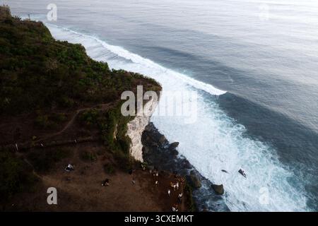 Vista aerea delle potenti onde che si infrangono contro le torreggianti scogliere calcaree bianche e le onde di Uluwatu, penisola di Bukit, Bali meridionale, Indonesia. Foto Stock