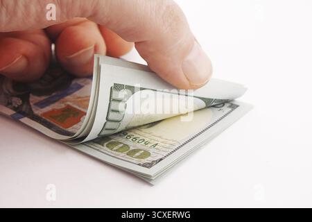 Un mucchio di soldi americani in mano, banconote da cento dollari su sfondo bianco, un sacco di banconote da cento dollari Foto Stock