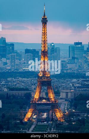 Parigi, 15 maggio 2024: La Torre Eiffel risplende al tramonto, con vista sullo skyline della città e sul quartiere degli affari la Defense. Foto Stock