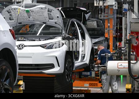 Zwickau, Germania. 13 ottobre 2025. I veicoli elettrici ID.3 e Cupra Born sono assemblati nello stabilimento Volkswagen di Zwickau. Finora, sei modelli Volkswagen, Audi e Cupra sono usciti dalla linea di produzione nello stabilimento di Sassonia. Lo stabilimento di Zwickau non funziona attualmente a piena capacità. La capacità è di oltre 300.000 veicoli all'anno; secondo la direzione, attualmente è poco più di 200.000. Crediti: Hendrik Schmidt/dpa/Alamy Live News Foto Stock