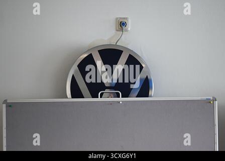 Zwickau, Germania. 13 ottobre 2025. Un logo VW può essere visto dietro una bacheca vuota in una sala riunioni presso lo stabilimento Volkswagen di Zwickau. Crediti: Hendrik Schmidt/dpa/Alamy Live News Foto Stock