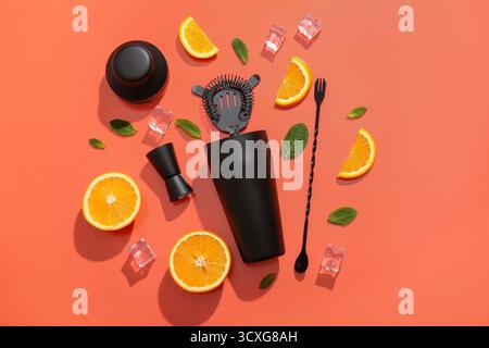 Utensili da barman con fette di arancia, cubetti di ghiaccio e foglie di menta su sfondo rosso Foto Stock