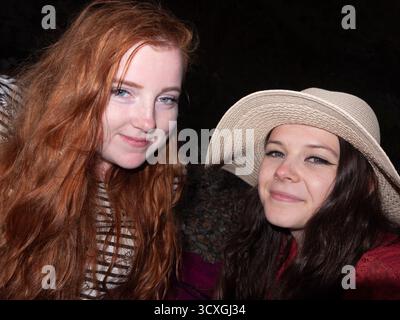 Due giovani amiche che sorridono insieme all'aperto la sera d'estate Foto Stock