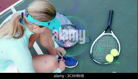 Tennista che si inginocchia allacciando il pizzo su un campo rigido con visiera, con borsa grigia, racchetta, palle Foto Stock