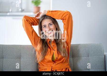 Donna di mezza età che riposa sul divano di casa in posa di massimo relax e sicurezza Foto Stock