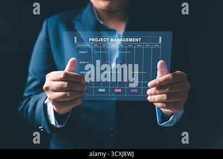 Il project manager sta lavorando su uno schermo virtuale, utilizzando il sistema di gestione dei progetti. Interfaccia cartografica Gantt per pianificare le attività, pianificare le tappe, monitorare i progressi Foto Stock