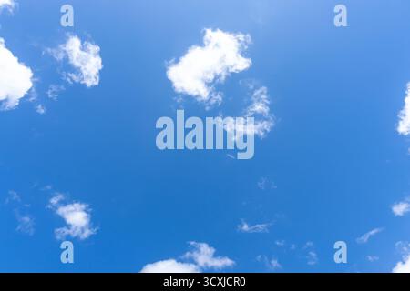 Vista ad angolo basso e cornice completa di un bellissimo cielo blu con strana forma di soffici nuvole bianche nel pomeriggio nella giornata di sole Foto Stock