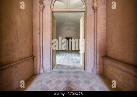 Edificio storico abbandonato interno con porte aperte e piano a scacchi Foto Stock