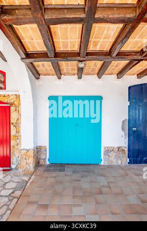 Casa tradizionale di pescatori con porte in legno turchese a Cala S'Alguer, un patrimonio culturale unico a Palamós, Girona, Spagna Foto Stock
