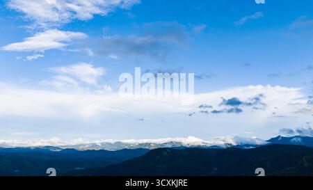 Vista droni della strada di montagna curva circondata da una fitta pineta Foto Stock