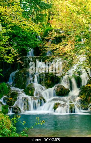 Splendida cascata a più livelli che scorre su pietre muschiate nella foresta di montagna pulita Foto Stock
