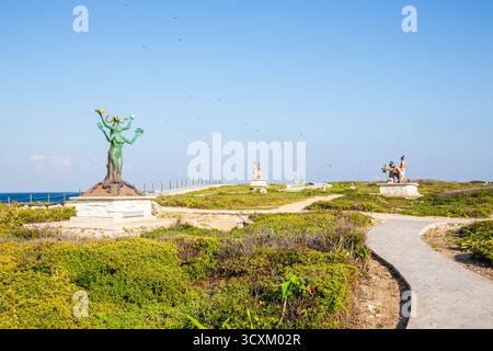 Isla Mujeres, Cancun, Messico Statua di una donna si trova su una collina vicino a un sentiero. La statua è circondata da cespugli e alberi Foto Stock