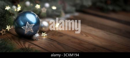 Palla di Natale blu e decorazioni su tavolo di legno scuro. Baule, stelle e rami di abete su una superficie rustica in legno in formato panoramico con spazio di copia. Foto Stock