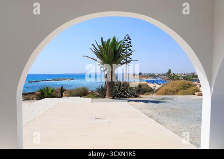 Vista dalla chiesa della cappella di Agia Thekla che guarda verso la spiaggia con i turisti che prendono il sole e nuotano. Ayia Napa Cipro Foto Stock