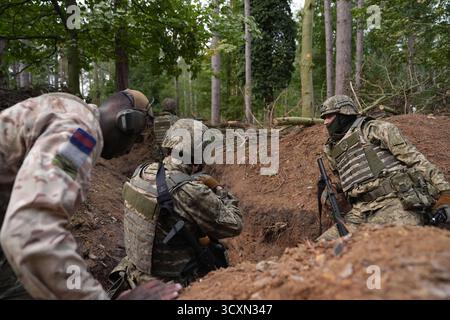I soldati ucraini, che stanno ancora seguendo il loro corso di formazione per la leadership nell'ambito dell'operazione Interflex guidata dal Regno Unito, prendono parte all'addestramento di trincea condotto da membri delle guardie irlandesi in un campo di addestramento dell'esercito britannico nell'Inghilterra orientale. Data foto: Mercoledì 15 ottobre 2025. Foto Stock