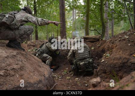 I soldati ucraini, che stanno ancora seguendo il loro corso di formazione per la leadership nell'ambito dell'operazione Interflex guidata dal Regno Unito, prendono parte all'addestramento di trincea condotto da membri delle guardie irlandesi in un campo di addestramento dell'esercito britannico nell'Inghilterra orientale. Data foto: Mercoledì 15 ottobre 2025. Foto Stock