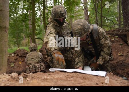 I soldati ucraini, che stanno ancora seguendo il loro corso di formazione per la leadership nell'ambito dell'operazione Interflex guidata dal Regno Unito, prendono parte all'addestramento di trincea condotto da membri delle guardie irlandesi in un campo di addestramento dell'esercito britannico nell'Inghilterra orientale. Data foto: Mercoledì 15 ottobre 2025. Foto Stock