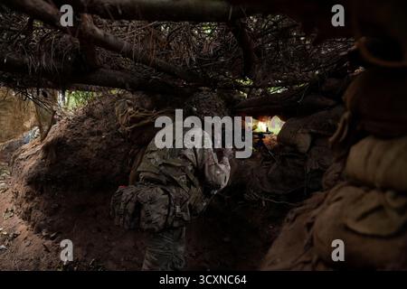 I soldati ucraini, che stanno ancora seguendo il loro corso di formazione per la leadership nell'ambito dell'operazione Interflex guidata dal Regno Unito, prendono parte all'addestramento di trincea condotto da membri delle guardie irlandesi in un campo di addestramento dell'esercito britannico nell'Inghilterra orientale. Data foto: Mercoledì 15 ottobre 2025. Foto Stock