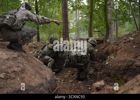 I soldati ucraini, che stanno ancora seguendo il loro corso di formazione per la leadership nell'ambito dell'operazione Interflex guidata dal Regno Unito, prendono parte all'addestramento di trincea condotto da membri delle guardie irlandesi in un campo di addestramento dell'esercito britannico nell'Inghilterra orientale. Data foto: Mercoledì 15 ottobre 2025. Foto Stock