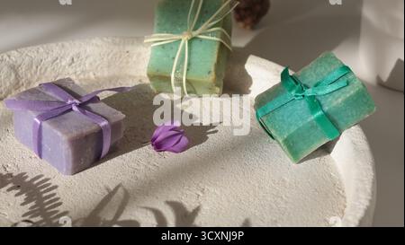 Cubi di sapone naturale sullo sfondo di elementi naturali. Artigianato e hobby. Cosmetici e bellezza. Prodotti ecocompatibili. Sfondo Foto Stock