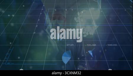 Chirurgo in posizione eretta che indossa abiti chirurgici per il monitoraggio della sovrapposizione digitale all'interno O sotto la lampada chirurgica Foto Stock