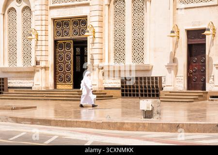 Jeddah, Arabia Saudita - 21 aprile 2025: Uomo arabo vestito di bianco che cammina di fronte alla Moschea Naghi a Jeddah, Arabia Saudita Foto Stock