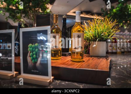 Esposizione di vino bianco giapponese su un bar di marmo con piante e carte Foto Stock