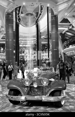 Immagine in bianco e nero di una Mercedes-Benz Cabriolet d'epoca esposta sotto la cascata dell'atrio illuminato Foto Stock