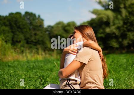 Momento gioioso di madre felice che passa del tempo con suo figlio. Ridere, baciare, abbracciare, solletico. Momento di genitorialità. Foto Stock