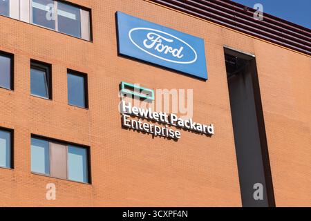 Il logo Hewlett Packard Enterprise e un logo Ford separato sono esposti su una grande facciata in mattoni di un edificio per uffici ad Amstelveen, Paesi Bassi. Amstelveen Foto Stock