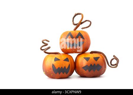 Simpatiche zucche di Halloween con facce di Jack-o'-lantern disposte in un gruppo giocoso su sfondo bianco Foto Stock