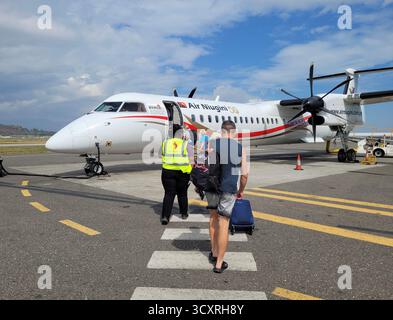 Passeggeri a bordo di un volo Air Niugini all'aeroporto di Port Moresby, Papua nuova Guinea, PNG Foto Stock
