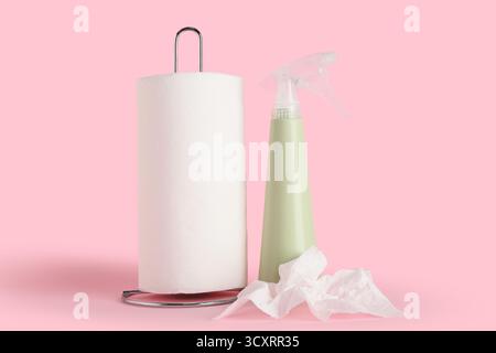 Asciugamani di carta con flacone di detergente su sfondo rosa Foto Stock