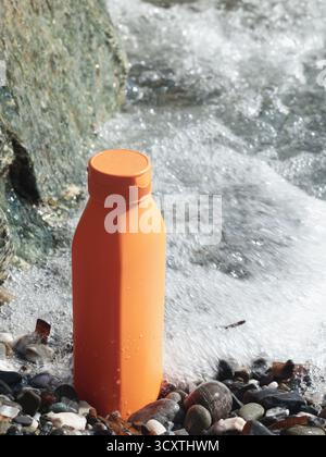 Vaso di bellezza rosso in plastica sullo sfondo di elementi naturali. Cosmetici e cura del viso e dei capelli. Modello per la progettazione. Prodotti ecocompatibili Foto Stock