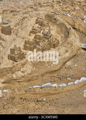 castello di sabbia su una spiaggia soleggiata. scultura di sabbia creativa. divertimento estivo Foto Stock