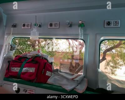 Una borsa rossa con una cinghia rossa si trova sul pavimento di un'ambulanza. Un altro sacchetto rosso con cinghia rossa è posizionato accanto ad esso. La scena sembra essere un farmaco Foto Stock