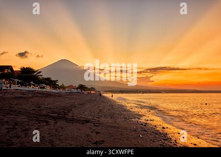 Vista panoramica del vulcano del monte Agung e della spiaggia di Amed al tramonto. Amed, Karangasem Regency, Bali, Indonesia. Foto Stock