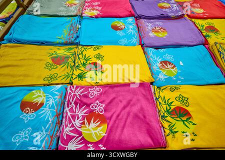 Ampia scelta di capi in tessuto di bambù piegati e esposti in un negozio di articoli da regalo. Kuta, Bali, Indonesia. Foto Stock