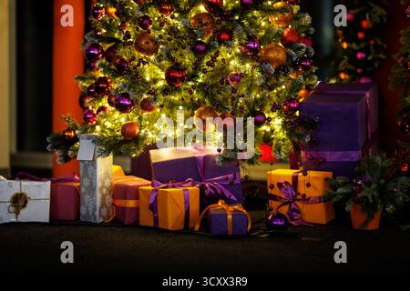 Un albero di Natale con molti ornamenti e regali sotto di esso. La scena è festosa e gioiosa Foto Stock