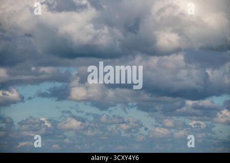 Basse nuvole di cumulus estive con basi scure che tengono docce in un giorno d'autunno, nuvole di Cumulus che raccolgono primi piani o cieli astratti Foto Stock